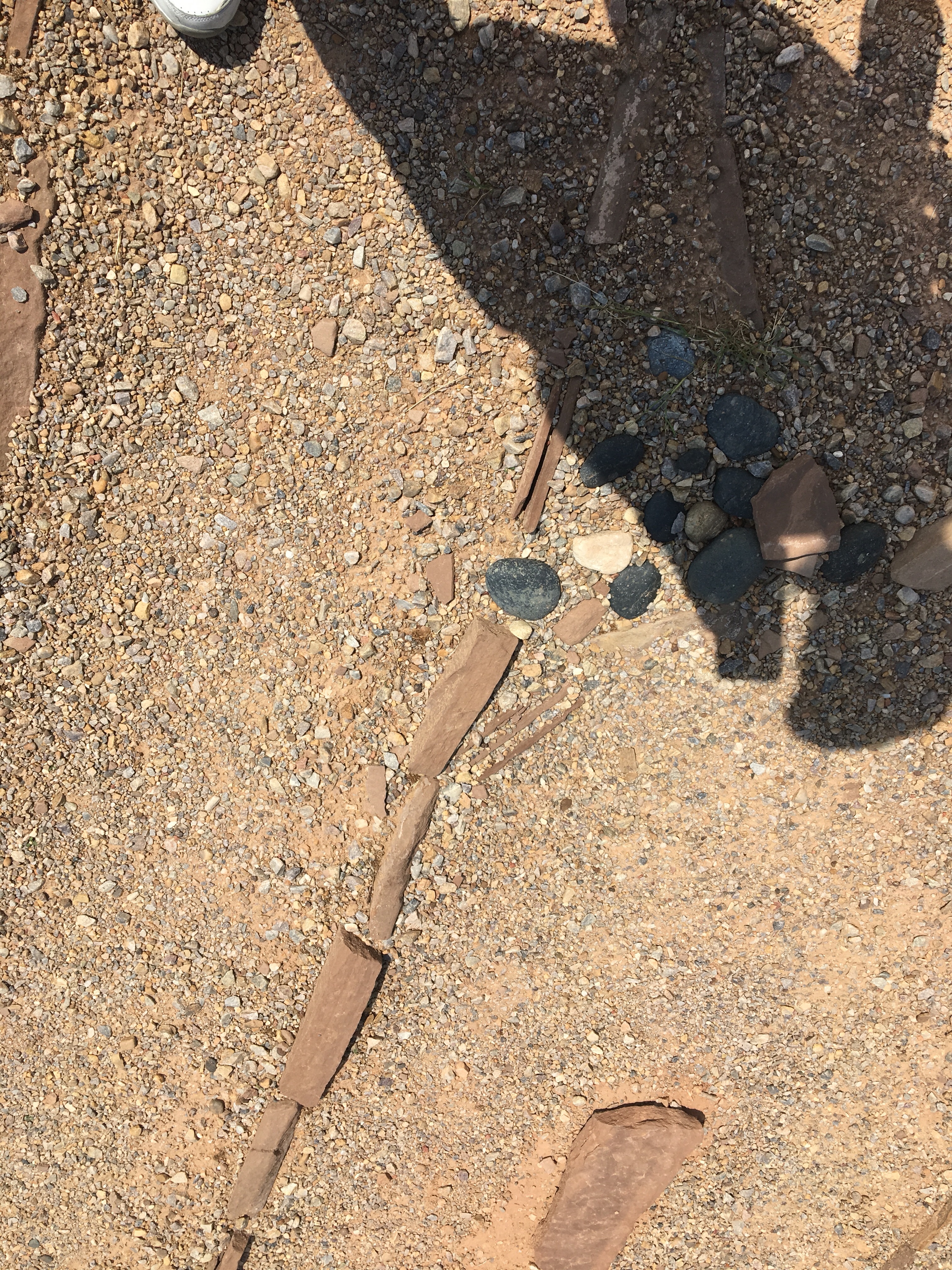 gravel paths, stone path-markers, blazing sun, shadow: a labyrinth at 3pm