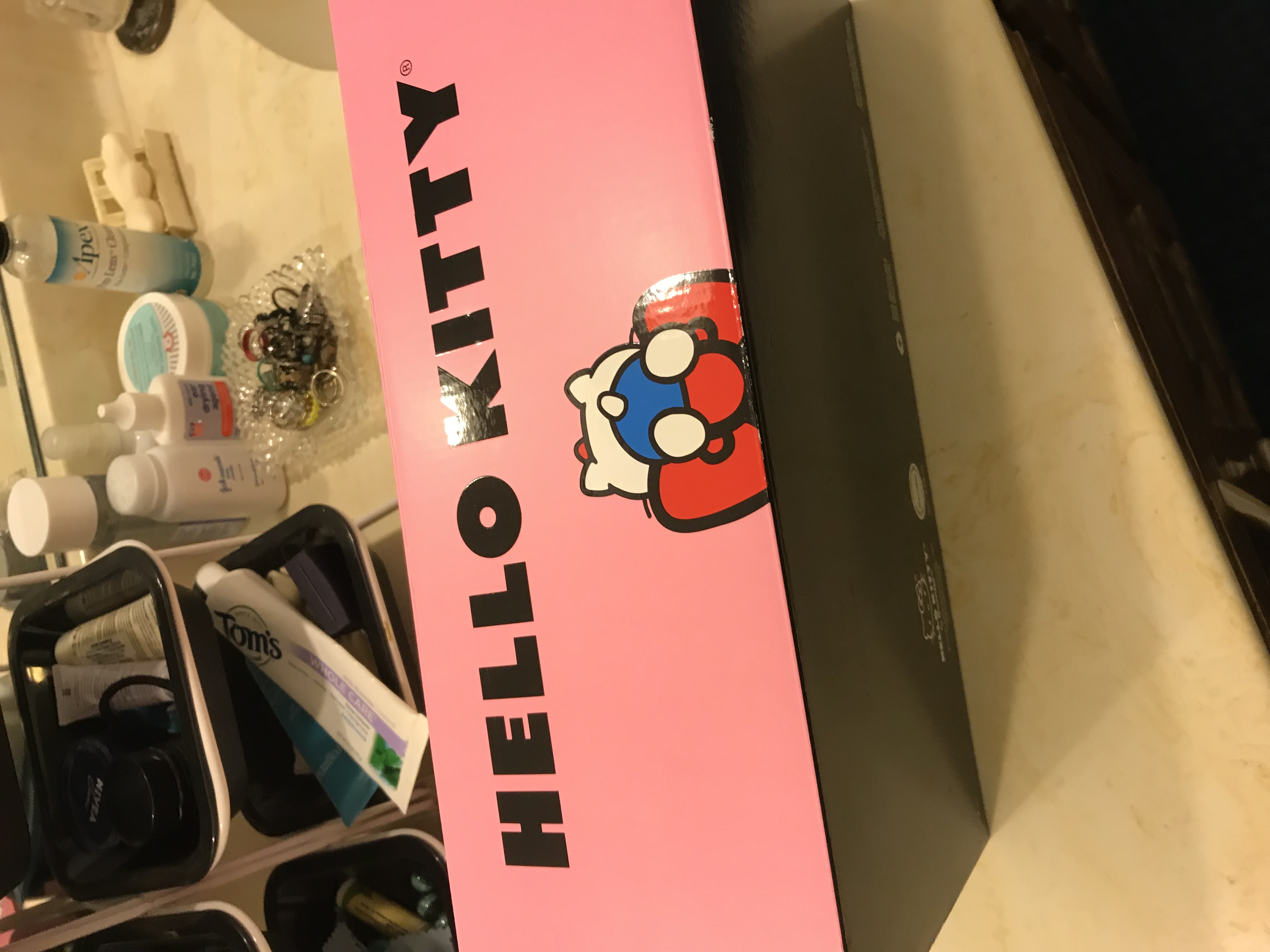 side view of the box, showing Kitty from the rear draped over the bow